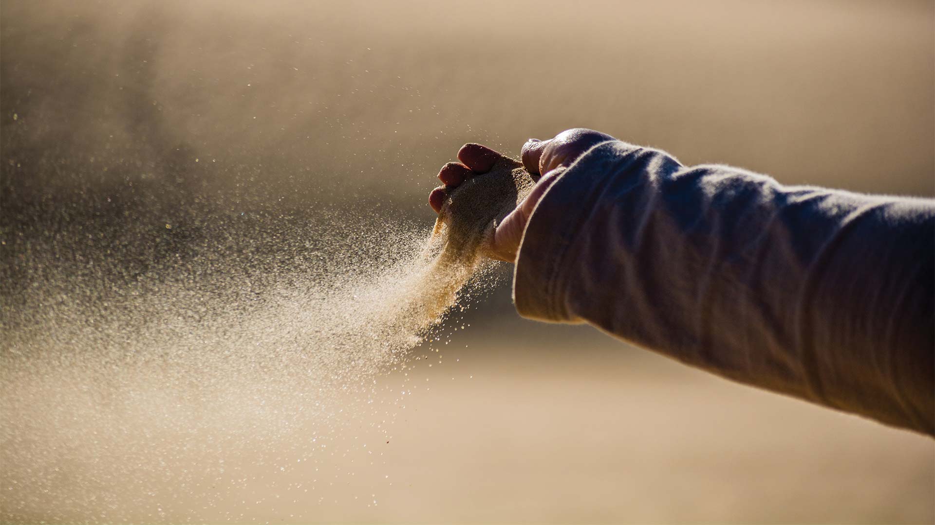 Sand pouring out of someones hand