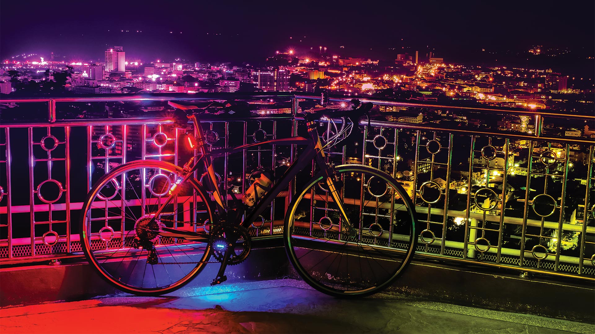 Colour night with bicycle against a fence