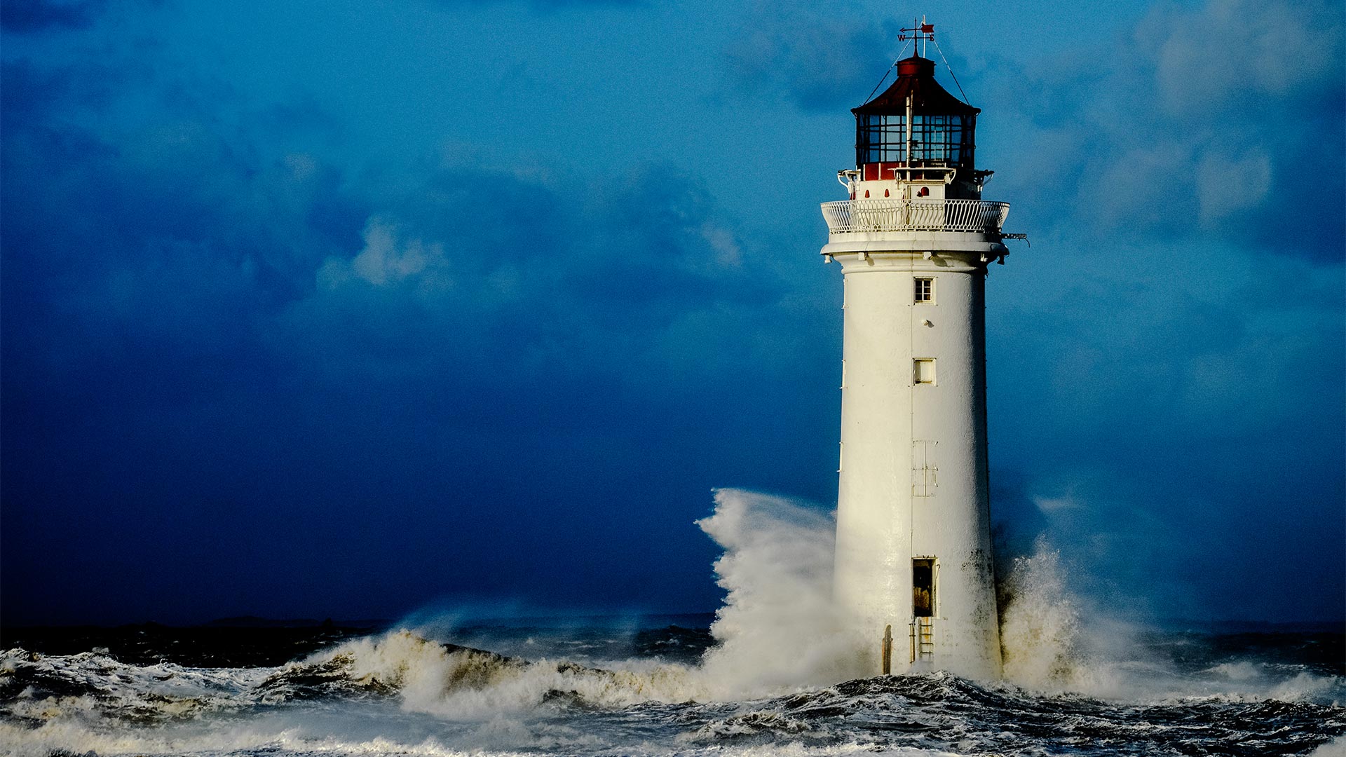 Lighthouse standing with waves crashing into it