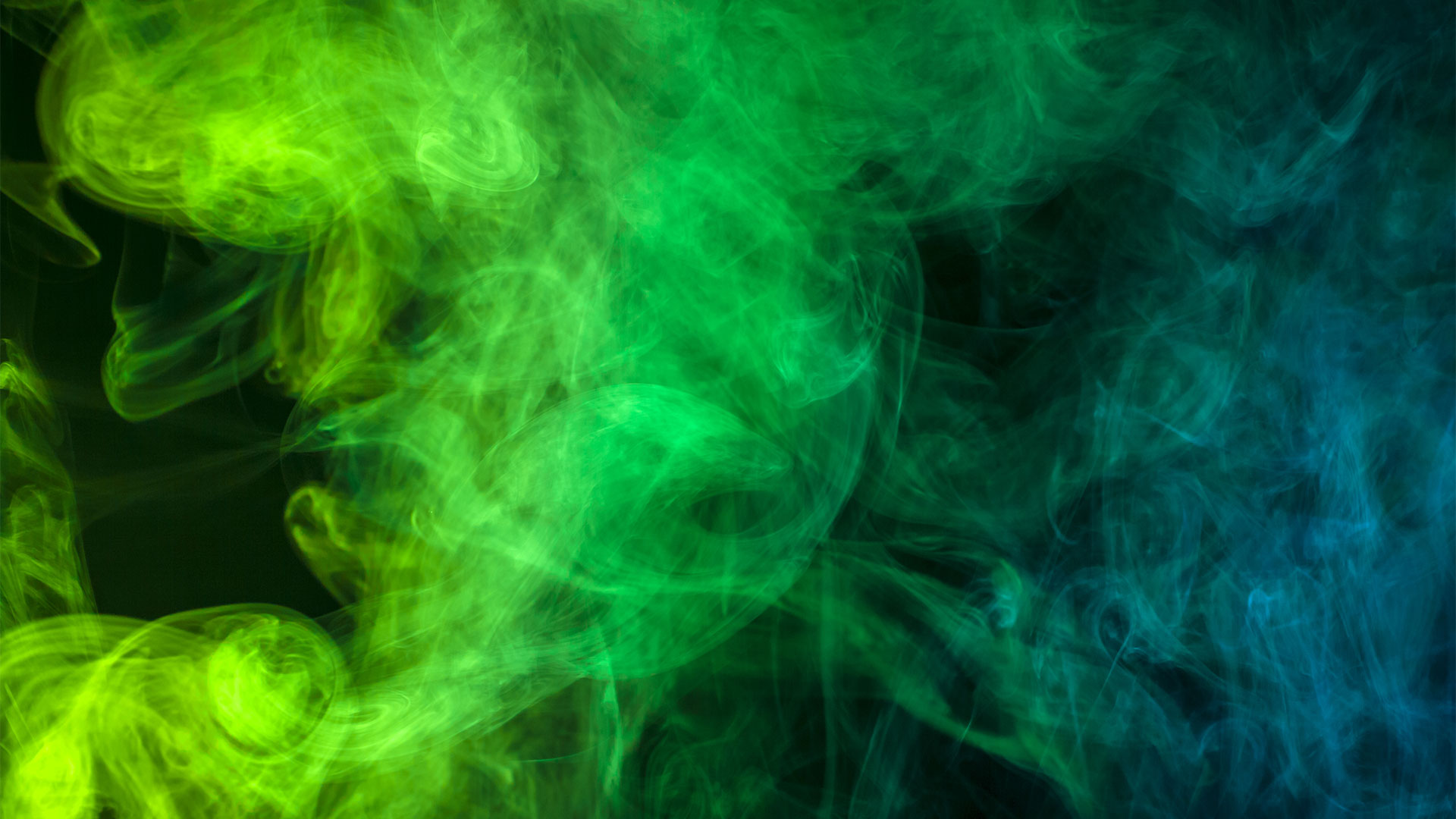 Green and blue smoke on a black background