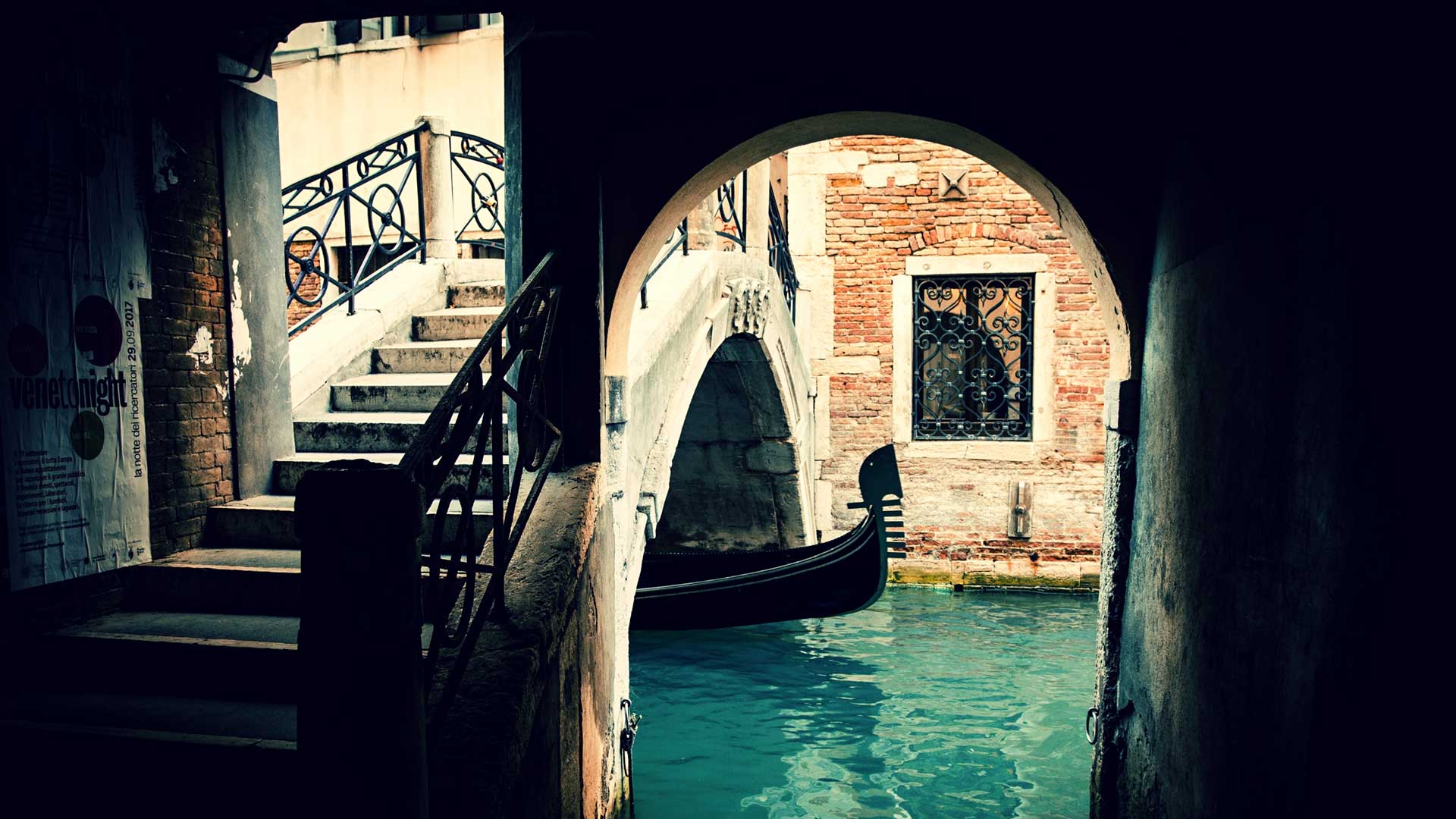 Hidden gondola under a bridge in Venice