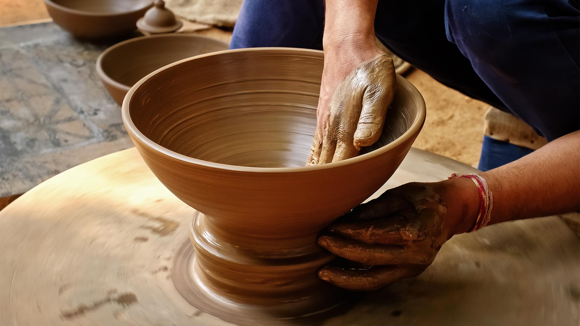 A potter transforming a lump of clay into a bowl