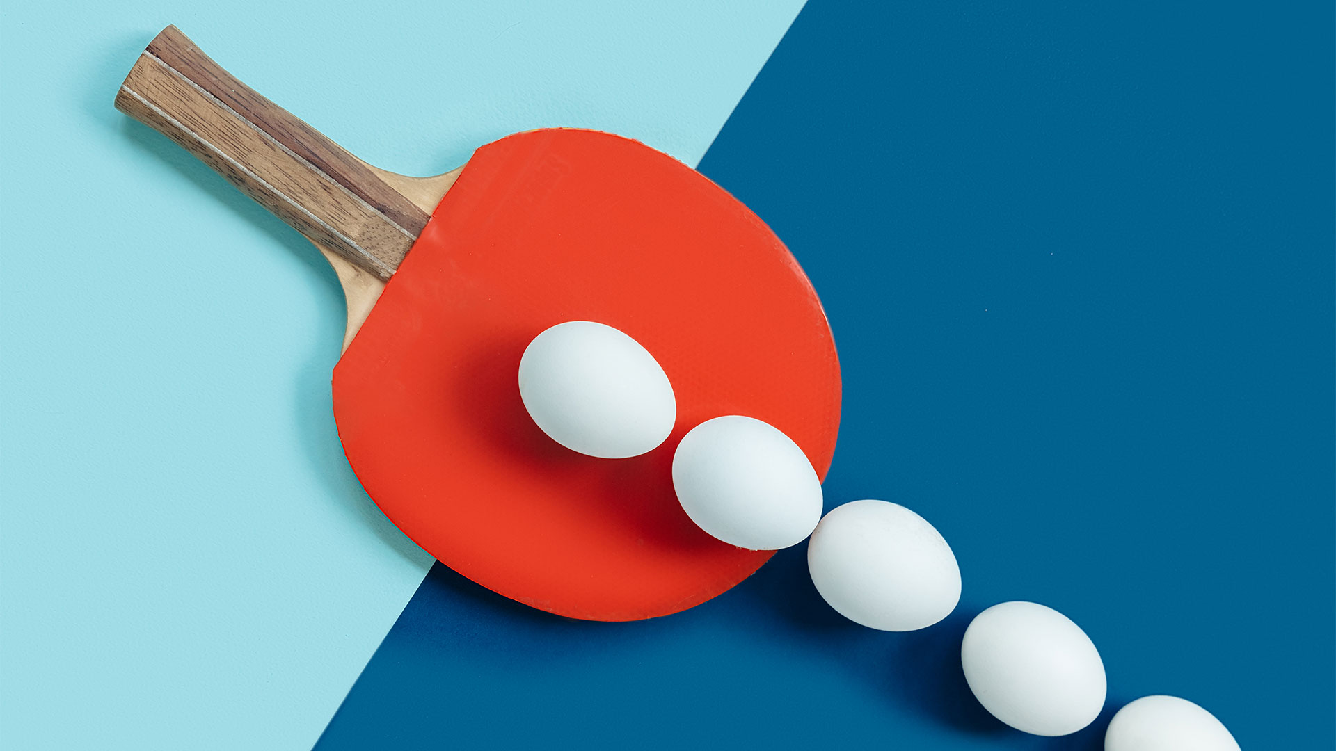 White eggs on table with a ping pong bat
