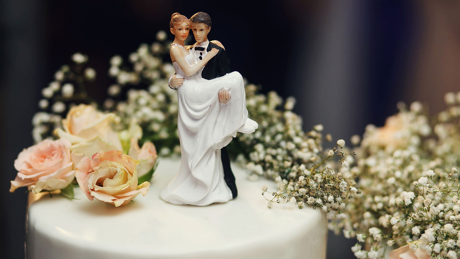 Wedding cake toppers of man and wife on top of cake