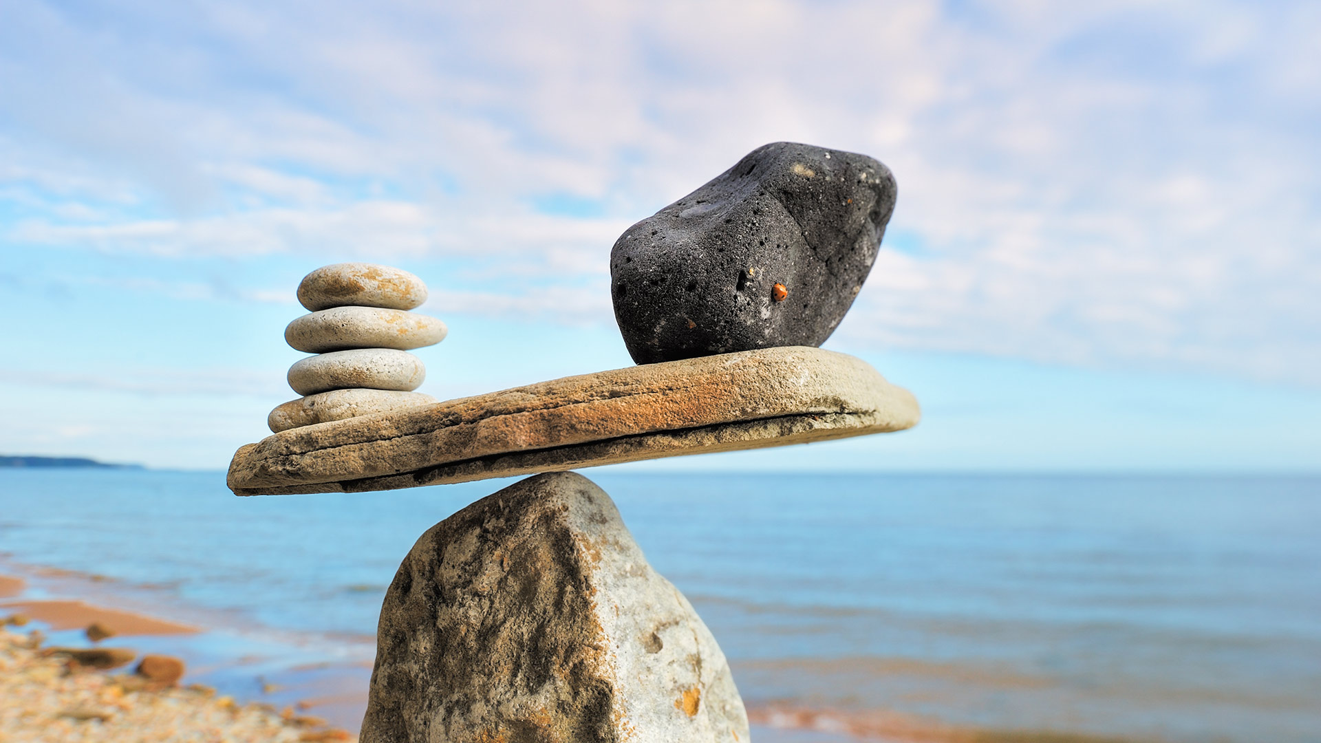 Wellbalanced stones on top of boulder at beach