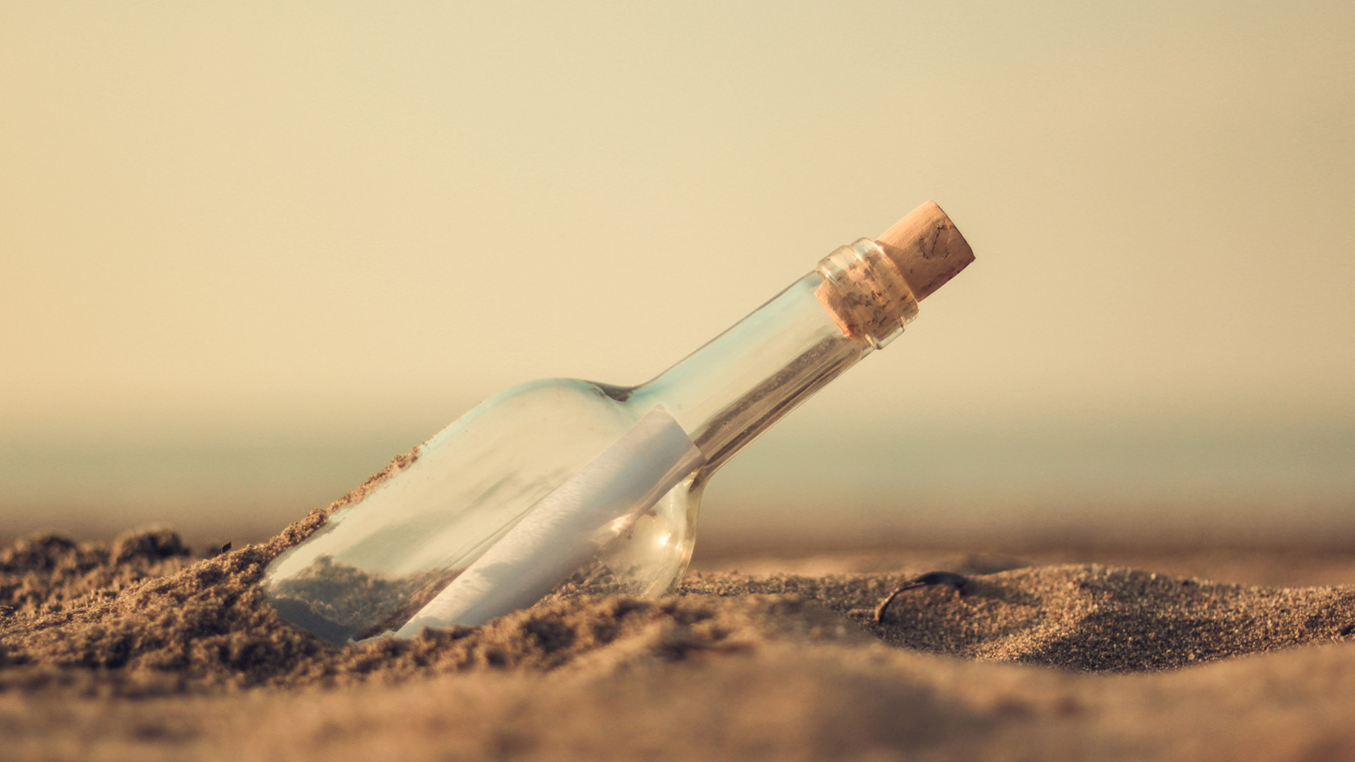 Message in a bottle found on a beach in the sand
