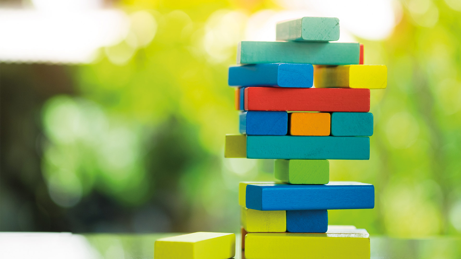 Close up of multicoloured jenga bricks stacked