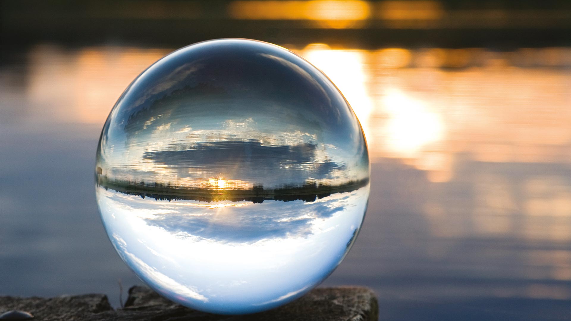 Glass ball looking out over a lake at sunset