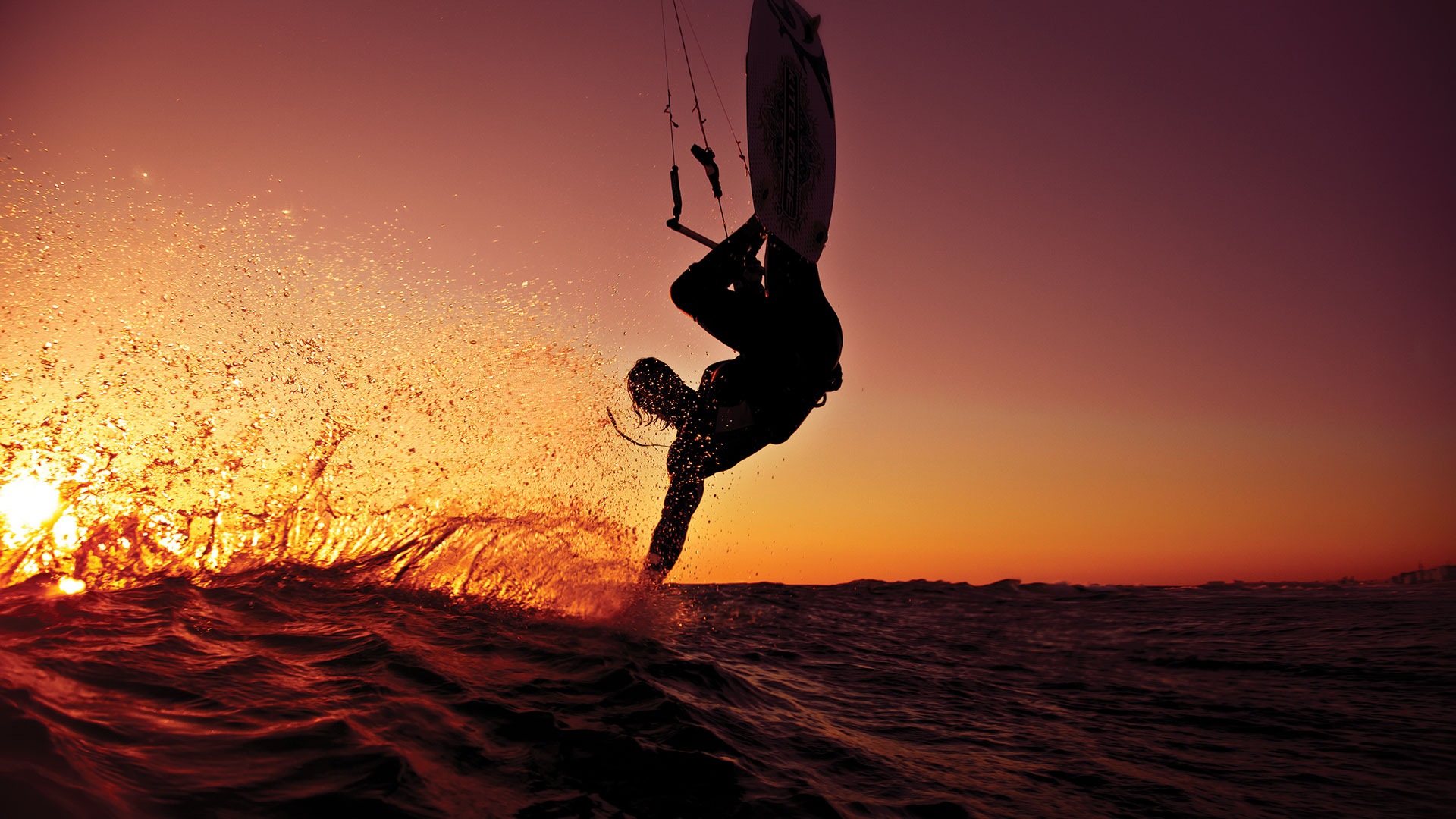 Person surfing at sunset