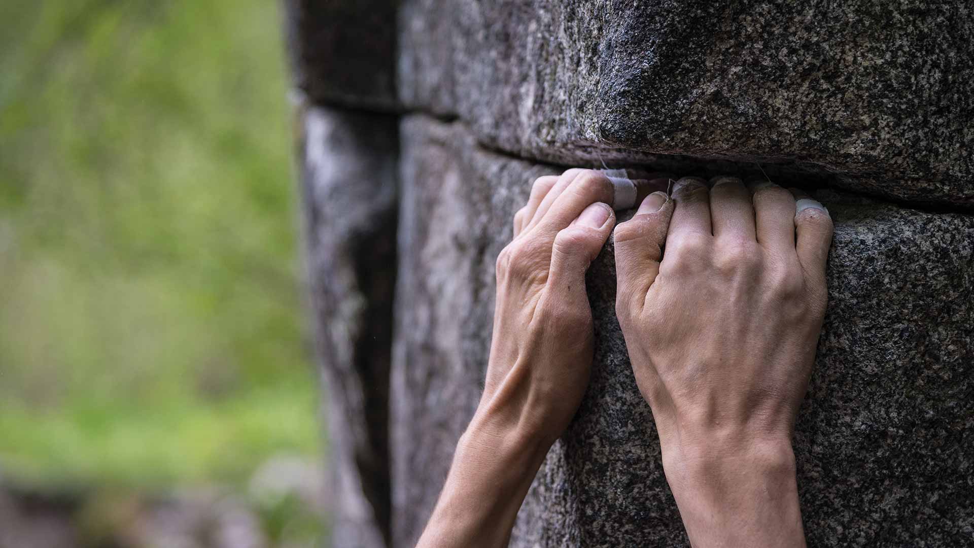 Hands gripping a rock ledge, holding themselves up
