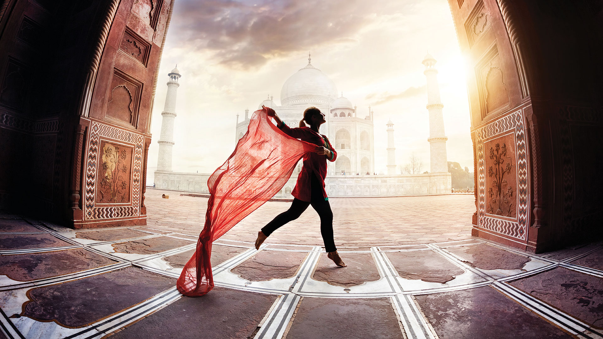 Woman with red scarf dancing near Taj Mahal