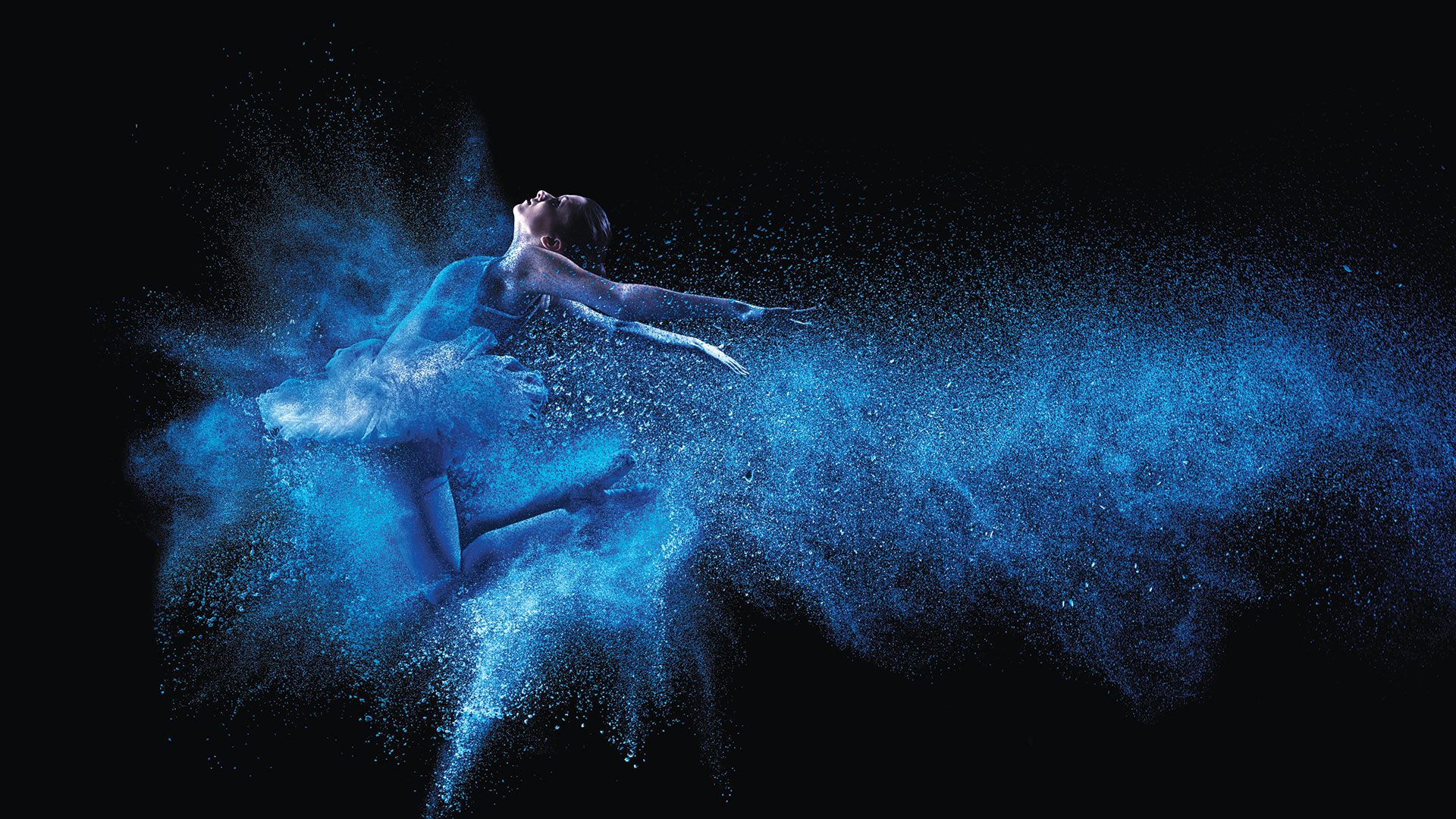 Dancer jumping into blue powder