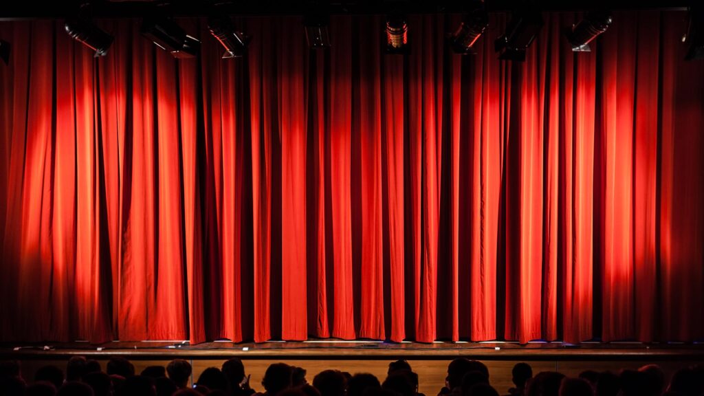 Closed red stage curtains in theatre