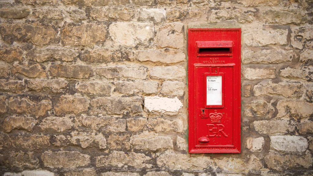 Red post box built into a brick wall