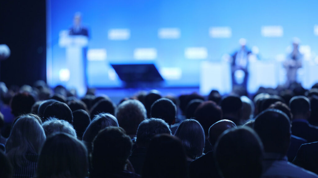 Audience in conference hall watching presentation