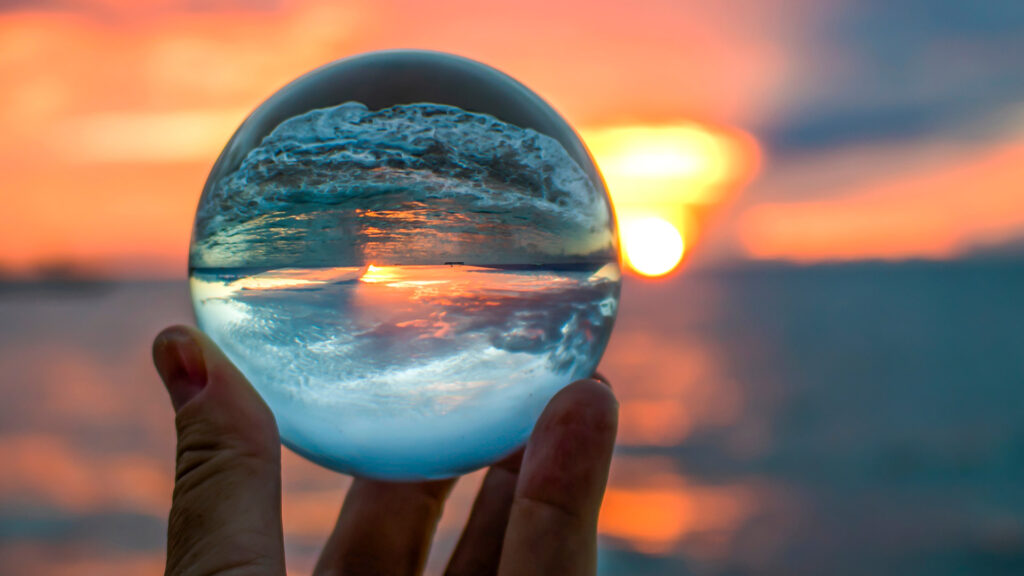 Crystal ball focussing on sunset on the beach