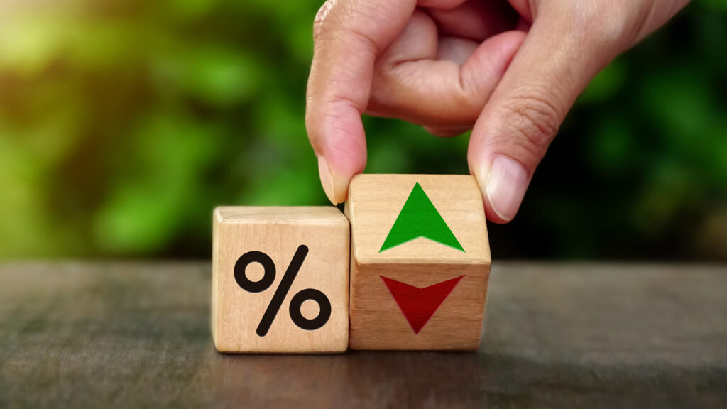 Person changing an upward arrow to a downward arrow in interest rates