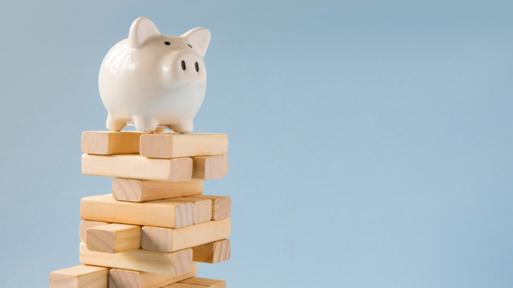 Piggy bank balancing on top of a Jenga tower