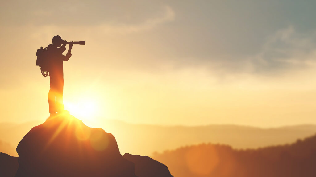 Person looking through a telescope whilst on a hike