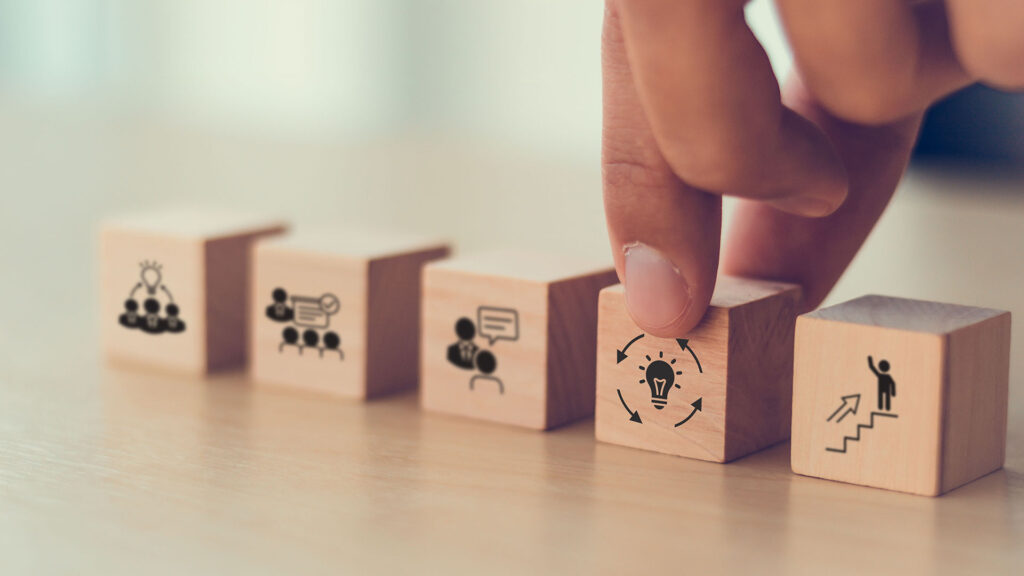 Person aligning wooden blocks that display skillsets on them