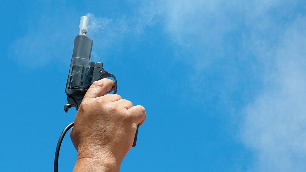 Starting pistol being fired into the sky