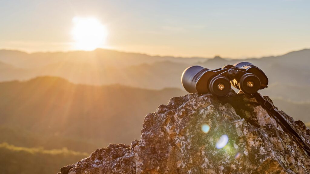 Binoculars balancing on rock, looking over the landscape