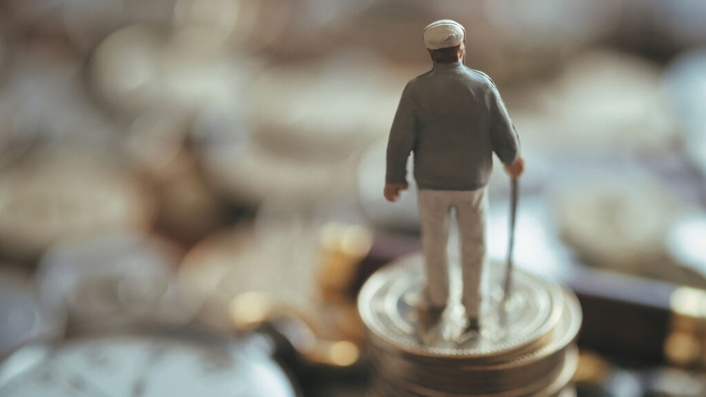 Miniture senior man with walking stick on top of money