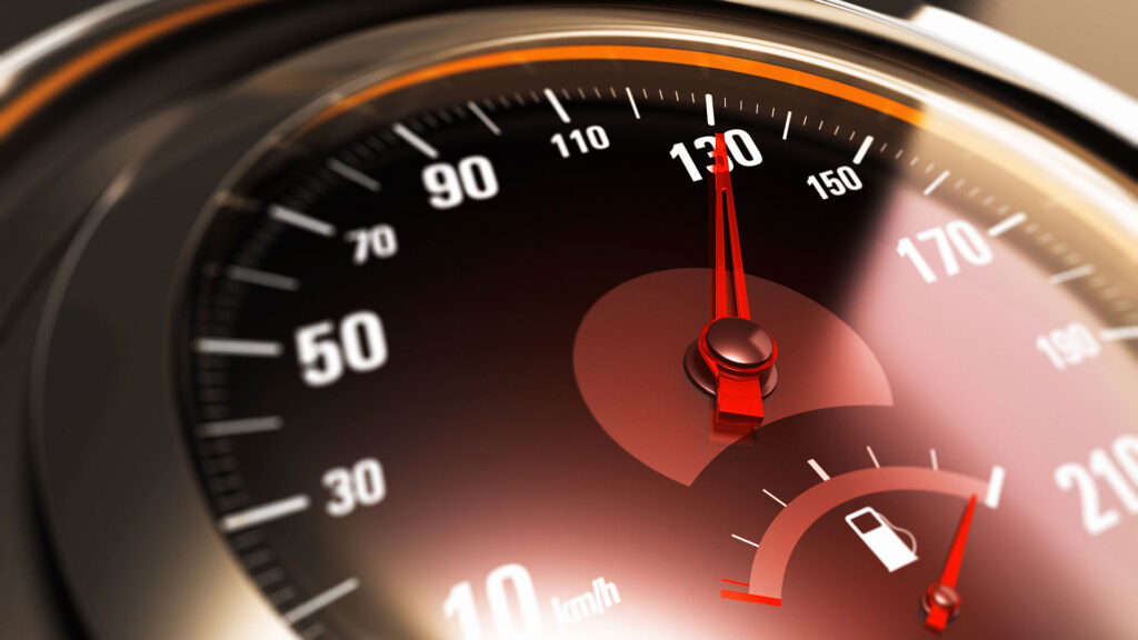 Close up of car speedometer with needle pointing at 130 mph