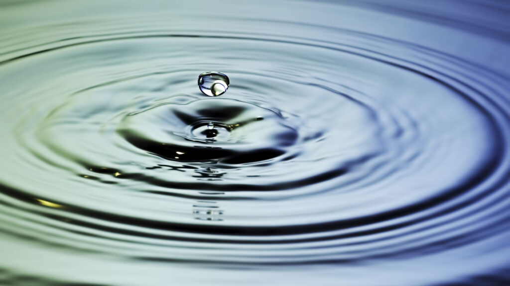 Water droplet in water creating ripples