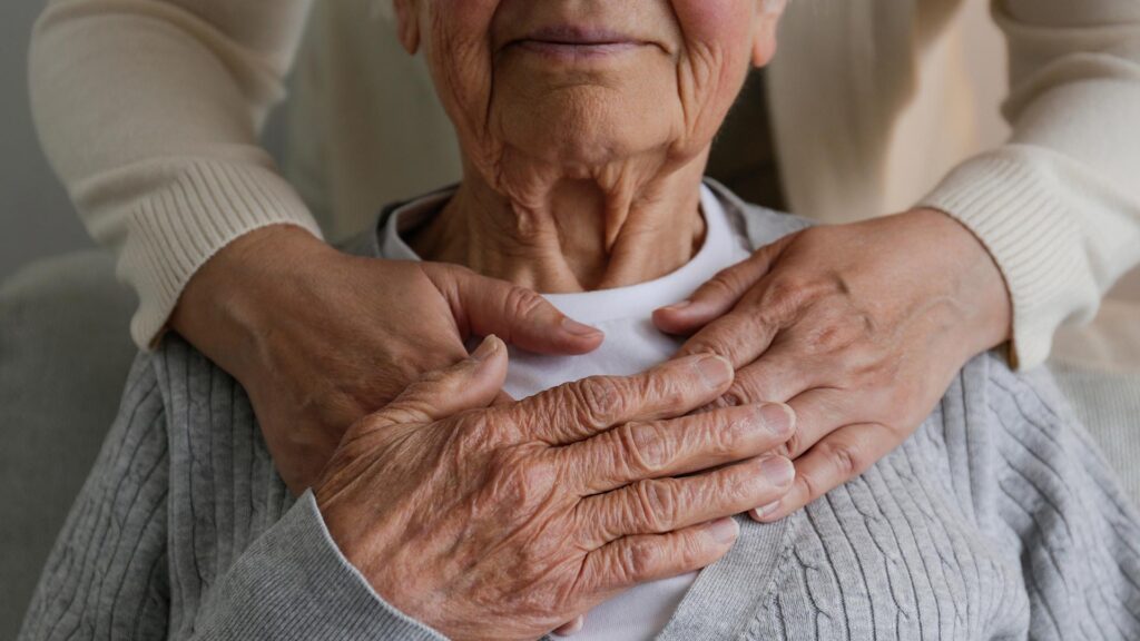 Person putting their hands on their grandmas shoulders