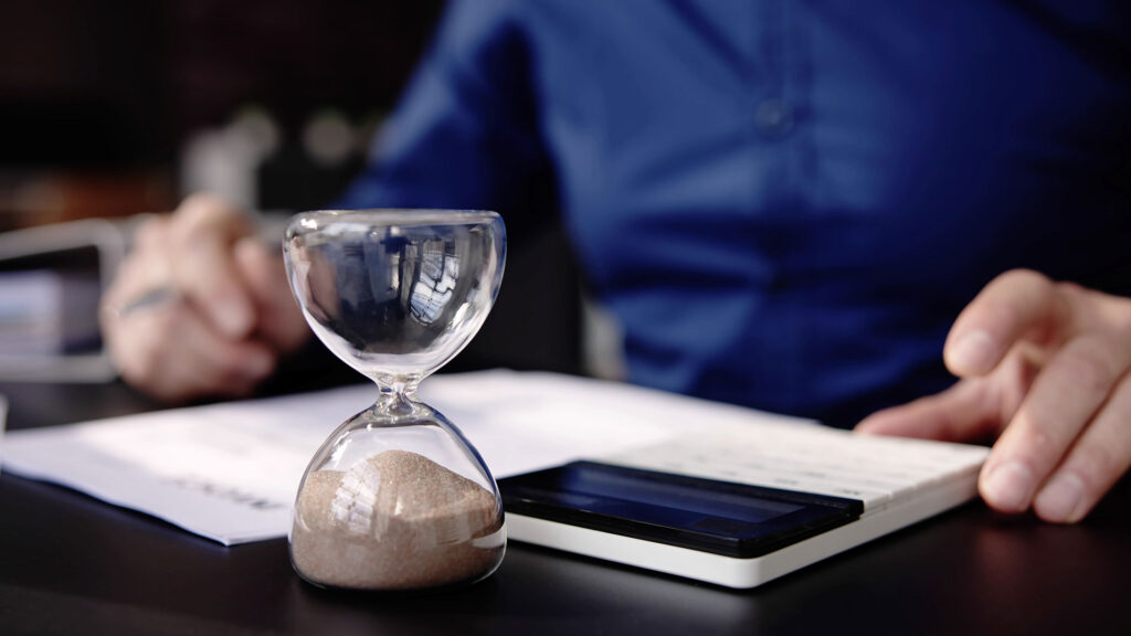 Sand hourglass run out of time when person is working out payments