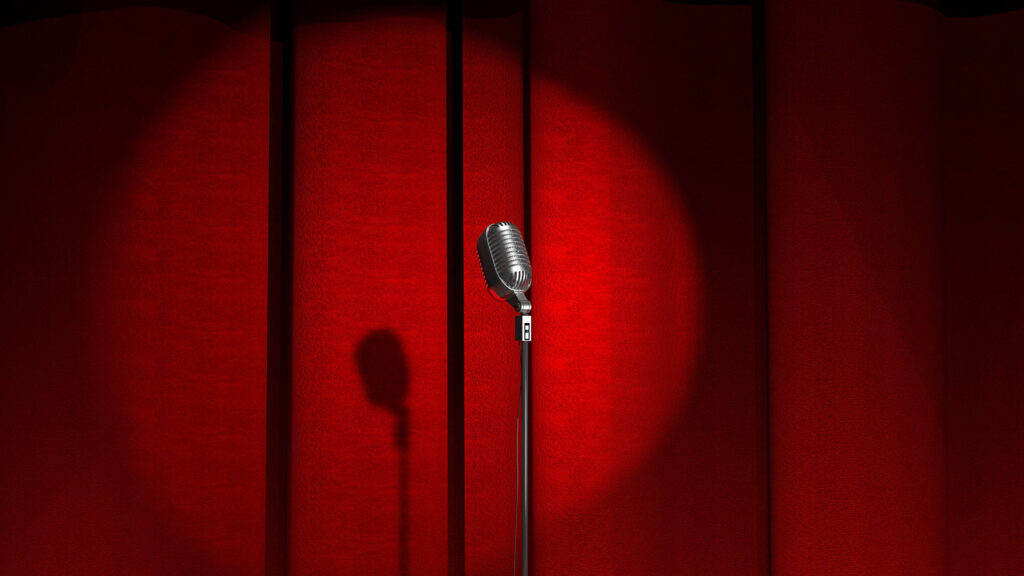 Spotlight focusing on a microphone on a stage.