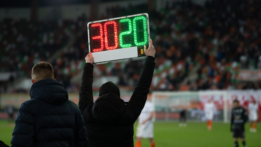 Substitution board being held up during football match.