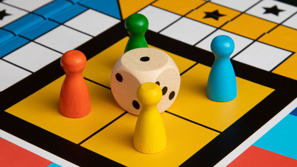 Board game with multicoloured figures and dice.