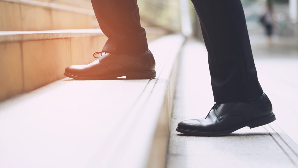 Businessman walking up step.