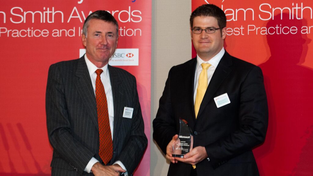 Photo of Richard Parkinson and Bart Wenstrom from Microsoft accepting on behalf of Stephanie Alston.