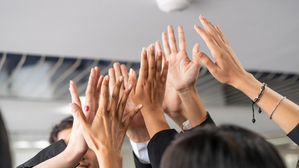 Business people holding hands up.