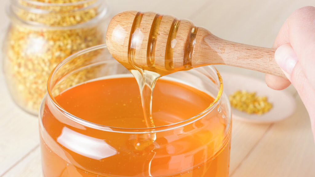 Pouring honey from a jar.