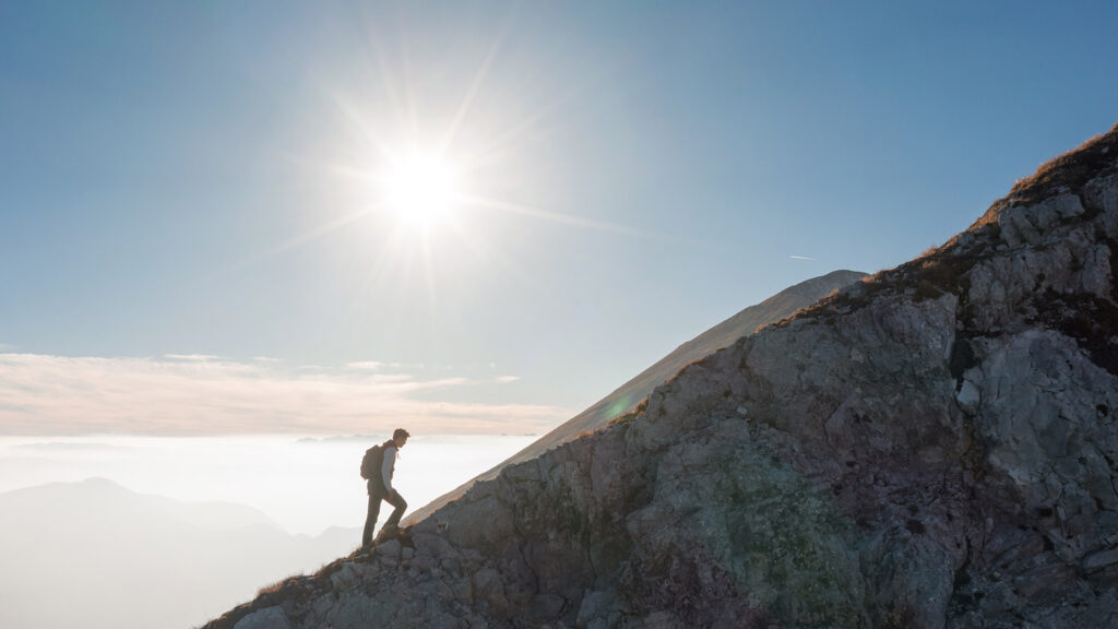Hiker climbing mountain.