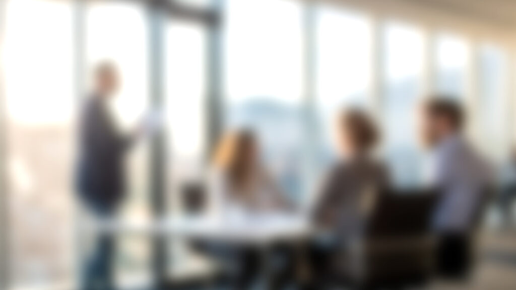 Office business meeting blurred with man standing.