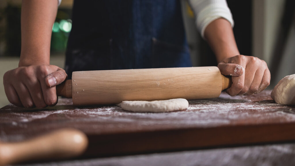 Baker using rolling pin.