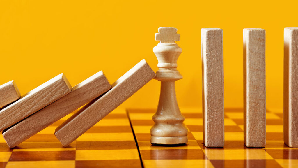 Chess pieces stopping dominos falling.