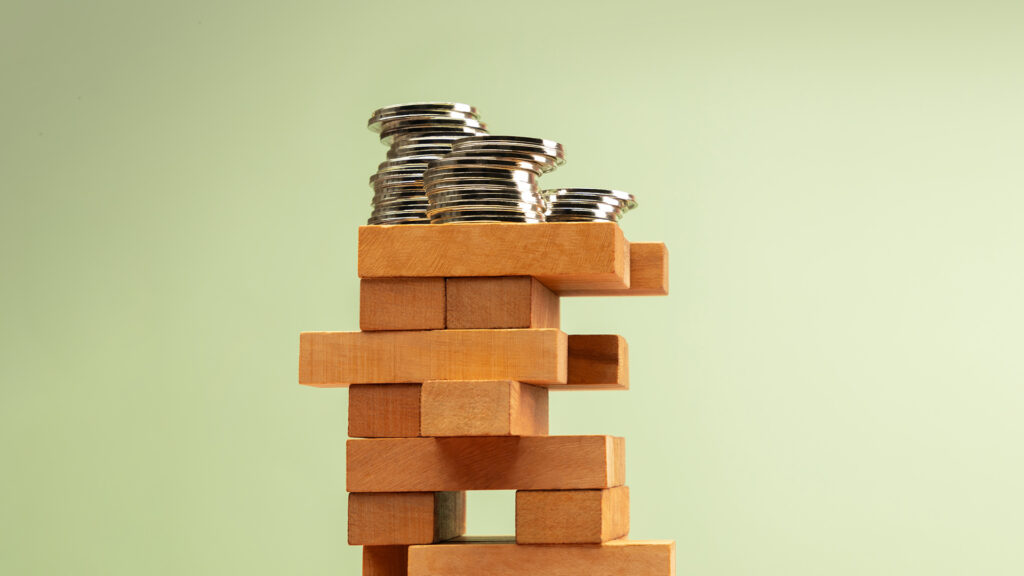 Coins stacked on Jenga blocks.