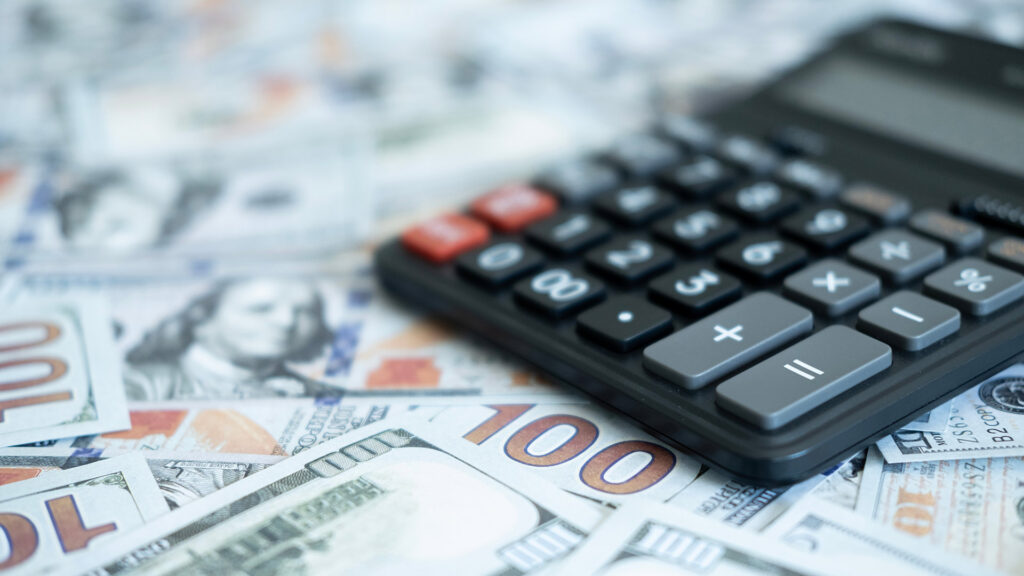 Calculator on a bed of dollar bills.